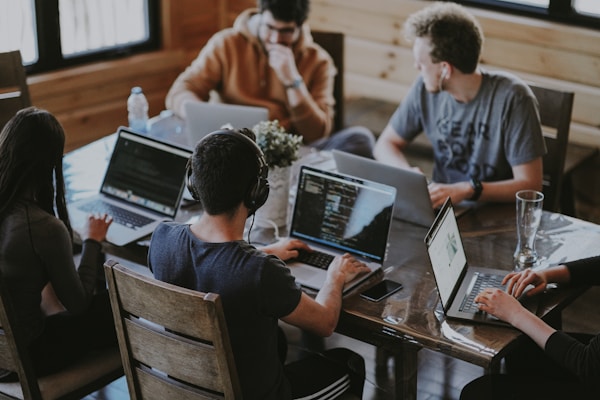 Team collaborating around a laptop in a modern office